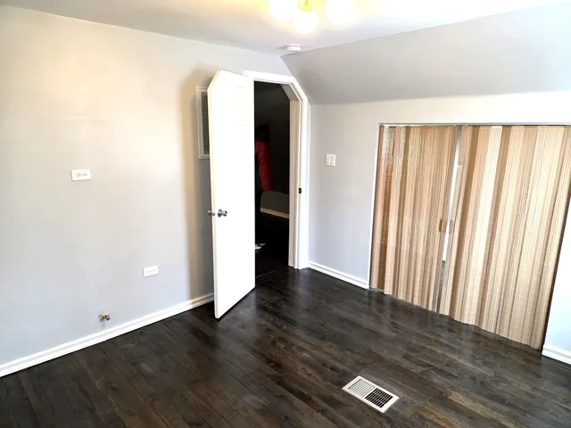 an empty room with wooden floor and closet