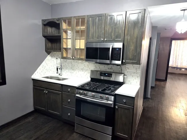 a kitchen with stainless steel appliances a stove microwave and sink
