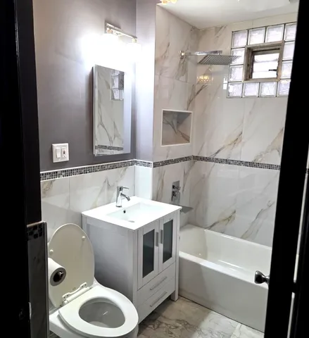 a bathroom with a sink and mirror with bathtub