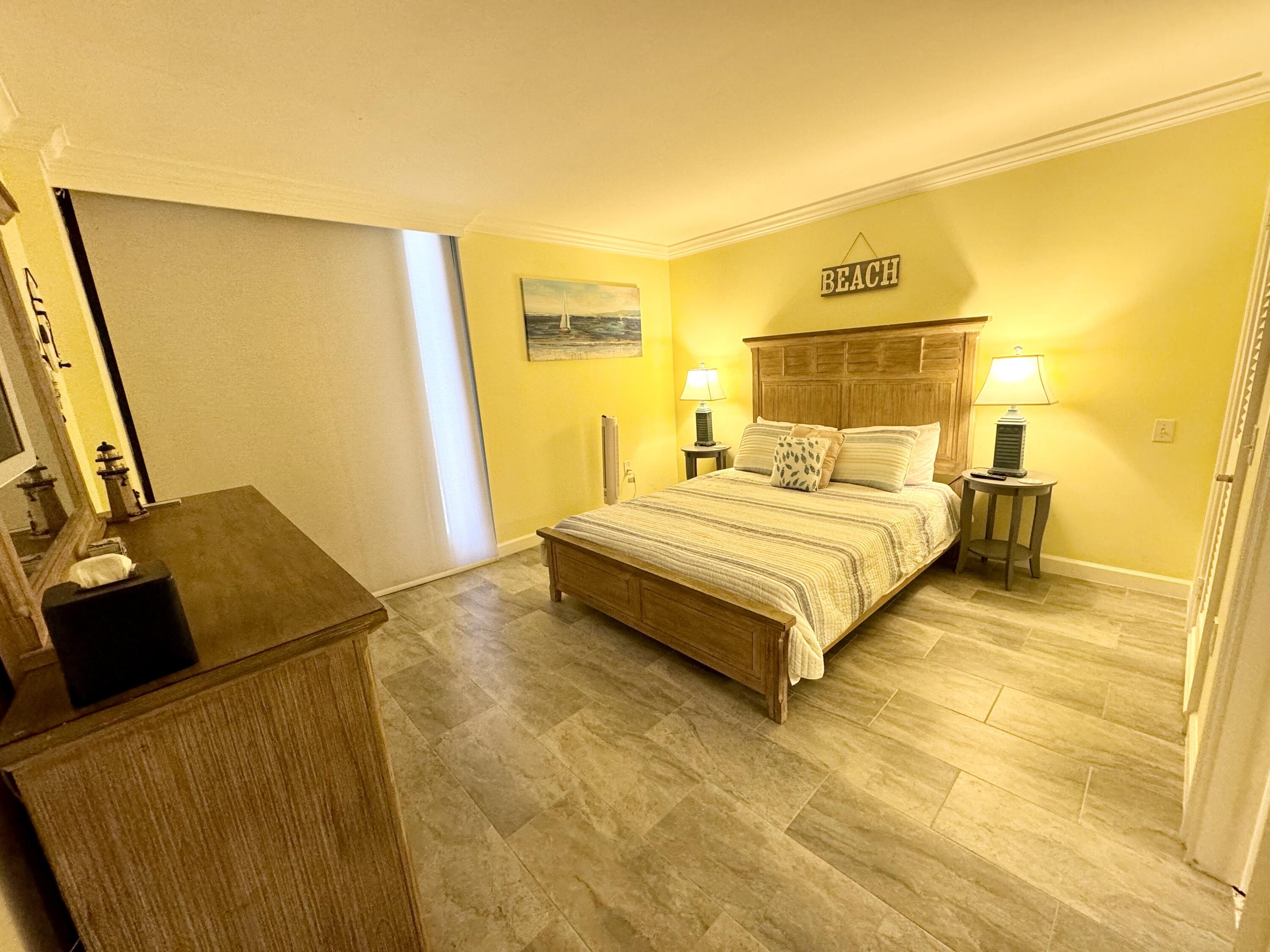 200 South Beach Road, Unit 403 Tequesta, FL 33469 - Photo 18 of 46 a bedroom with a bed and wooden floor