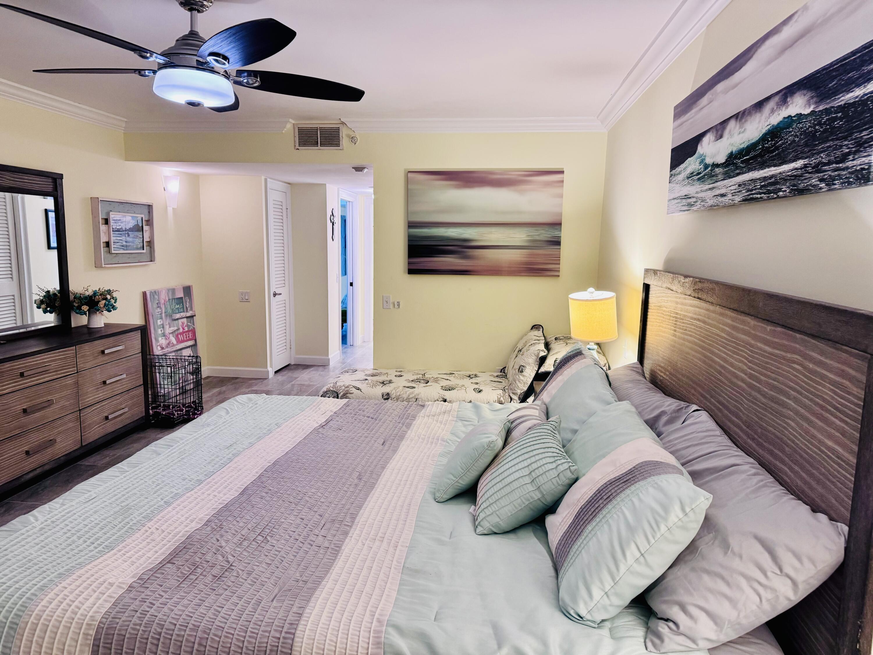 200 South Beach Road, Unit 403 Tequesta, FL 33469 - Photo 24 of 46 a bedroom with a bed and a chandelier