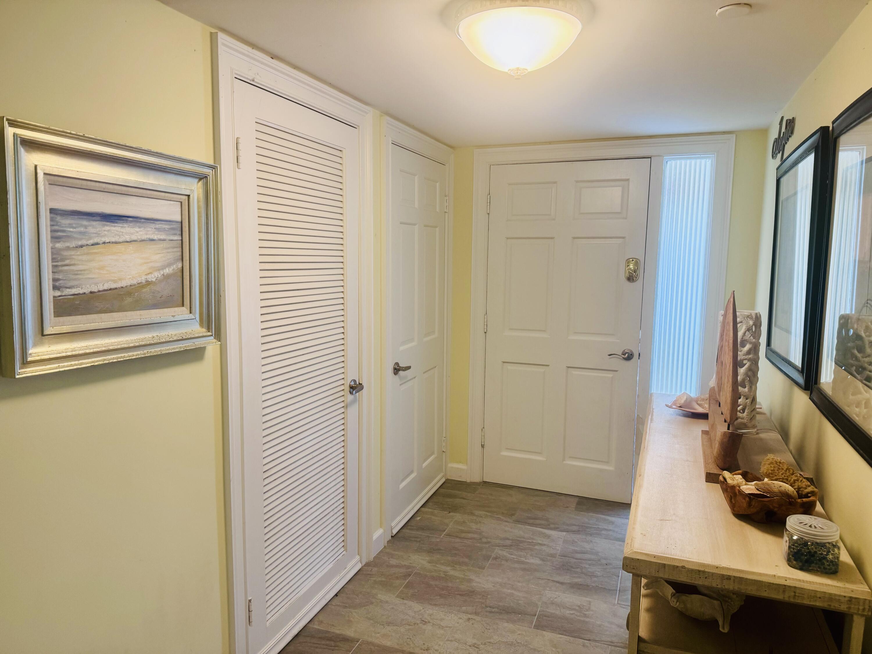 200 South Beach Road, Unit 403 Tequesta, FL 33469 - Photo 6 of 46 a view of a hallway with workspace and closet with wooden floor