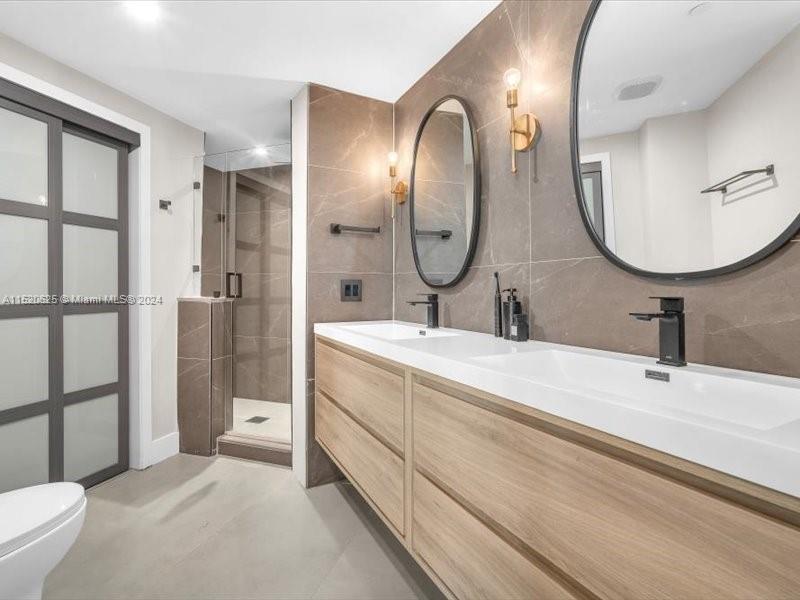 a en suite bathroom with a double vanity sink double mirror and a shower