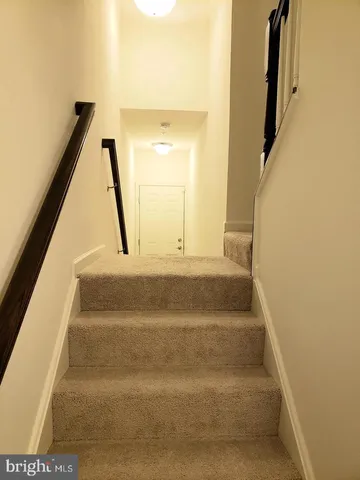 a view of staircase with white walls and a window