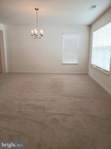 en empty room with windows and ceiling fan