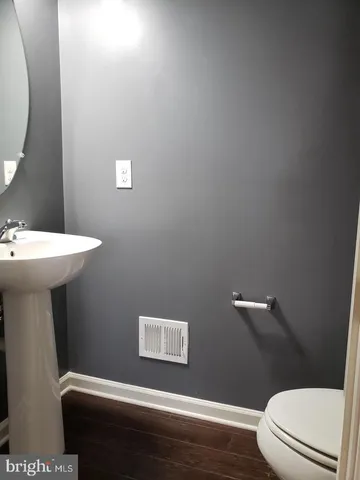 a bathroom with a toilet a sink and mirror