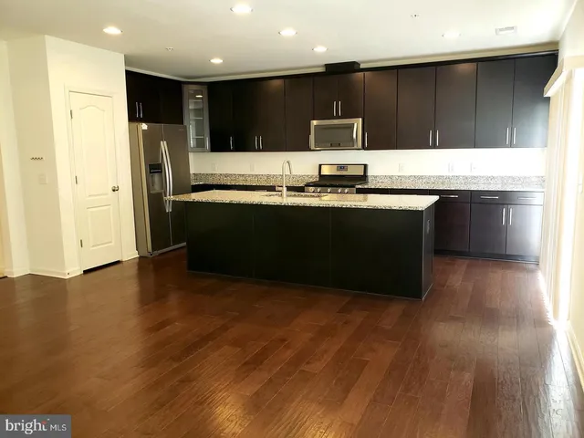 a kitchen with stainless steel appliances granite countertop a refrigerator and a stove top oven