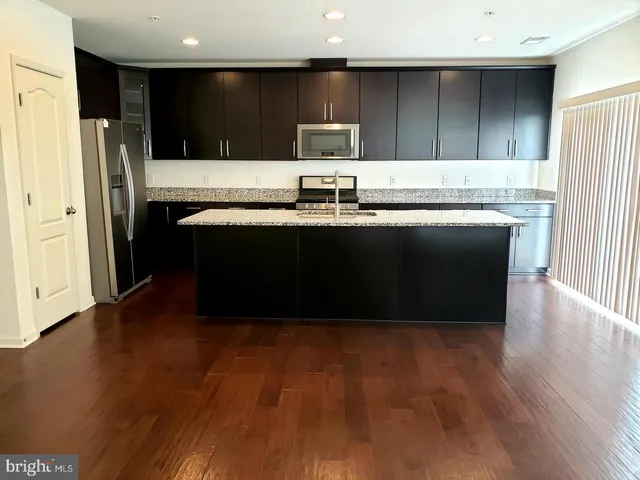 a kitchen with stainless steel appliances granite countertop a refrigerator and a sink