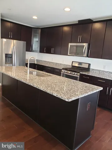 a kitchen with stainless steel appliances granite countertop a sink a stove and a refrigerator