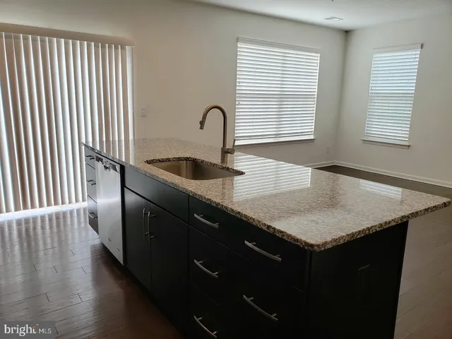 a kitchen with granite countertop cabinets a sink and a window
