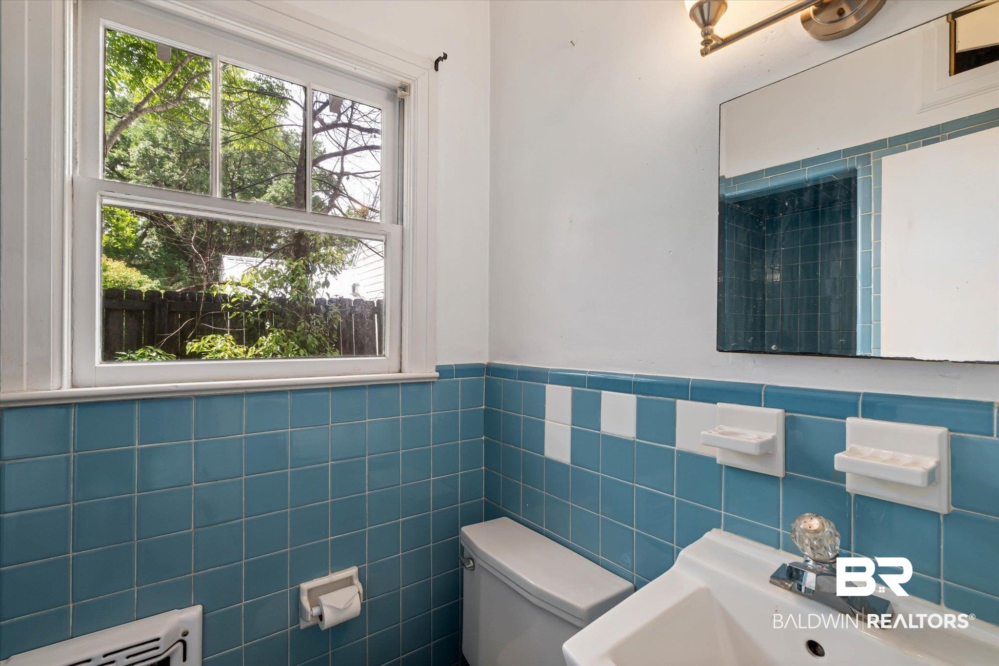 121 Westwood Street Mobile, AL 36606 - Photo 11 of 20 Half bath with toilet, a wainscoted wall, a sink, and tile walls