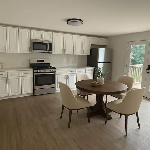 a kitchen with stainless steel appliances granite countertop a stove a microwave a dining table and chairs with wooden floor