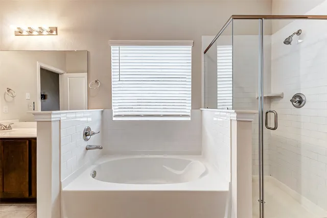 a bathroom with a bathtub a shower a sink and a window