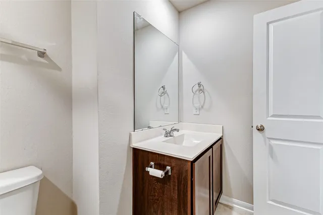 a bathroom with a sink vanity and toilet