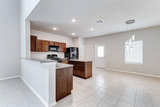 a kitchen with stainless steel appliances granite countertop a refrigerator oven a sink dishwasher and white cabinets with wooden floor