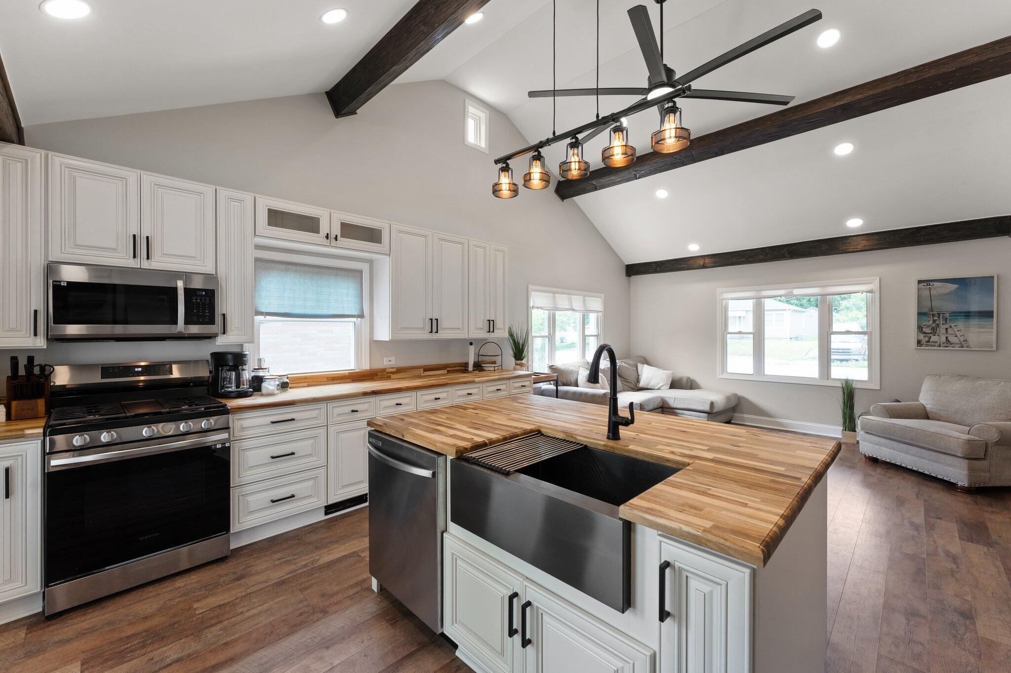 355 South Howard Street Gary, IN 46403 - Photo 2 of 16 a kitchen with stainless steel appliances granite countertop a sink a stove and a microwave oven with wooden floor