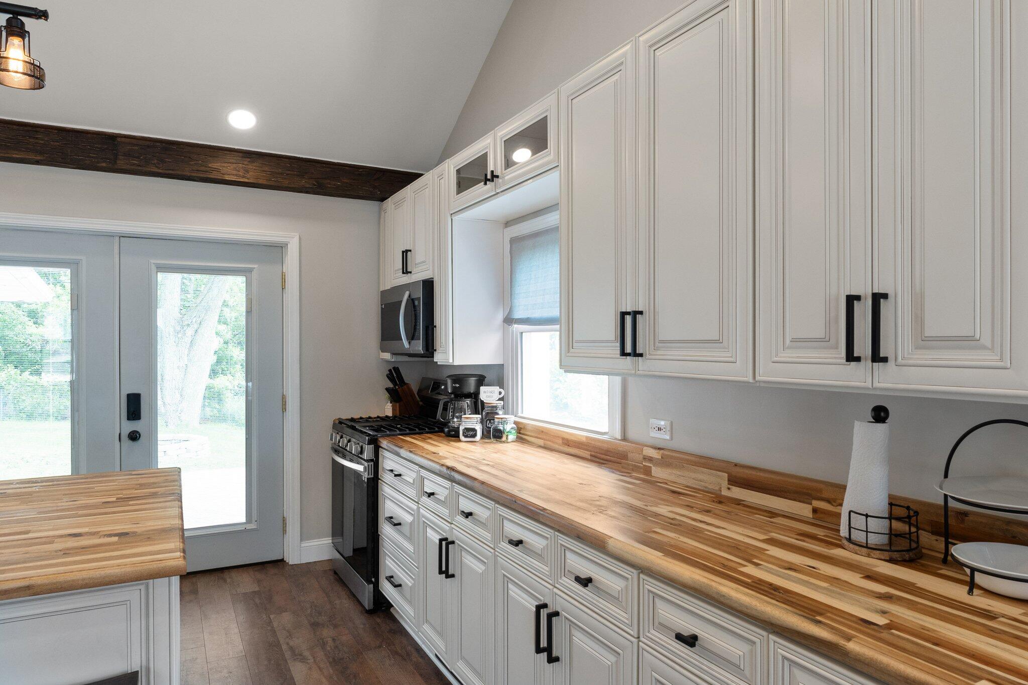 355 South Howard Street Gary, IN 46403 - Photo 4 of 16 a kitchen with granite countertop white cabinets and white appliances