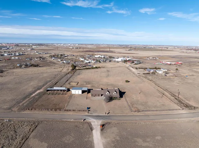 a kitchen with stainless steel appliances granite countertop a refrigerator a sink dishwasher a stove and white cabinets with wooden floor