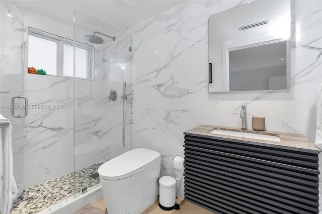 a bathroom with a sink a toilet and shower