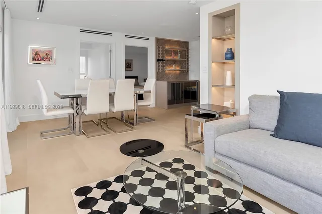 a living room with furniture a rug and a chandelier