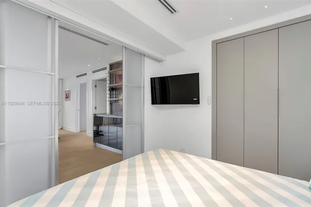 a bedroom with a bed and a flat screen tv