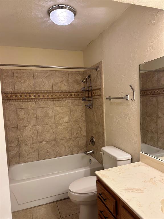 336 Melrose Drive, Unit 7B Richardson, TX 75080 - Photo 4 of 18 Full bathroom featuring vanity, a textured wall, tile patterned floors, tub / shower combination, and a textured ceiling