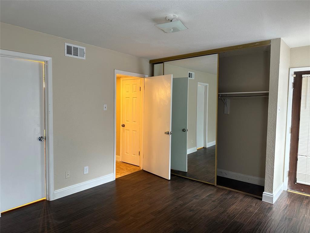 336 Melrose Drive, Unit 7B Richardson, TX 75080 - Photo 6 of 18 Unfurnished bedroom with dark wood-type flooring and a closet