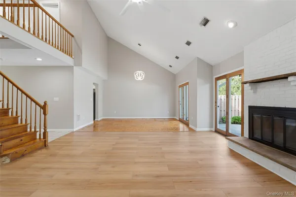 a view of an empty room with a fireplace and a window
