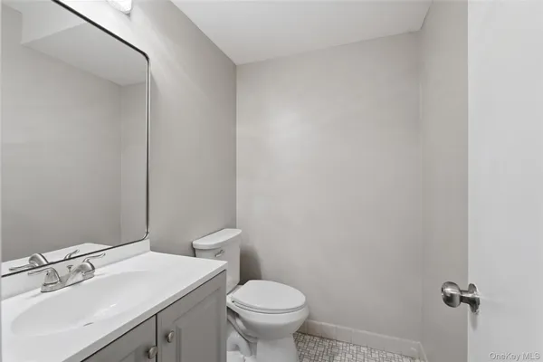 a bathroom with a sink a toilet and a mirror