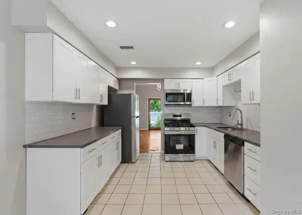a kitchen with stainless steel appliances granite countertop a refrigerator and a stove top oven