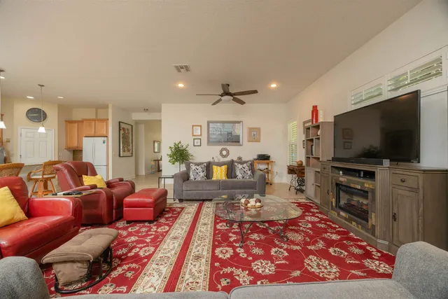a large kitchen with lots of white furniture a dining table and chairs