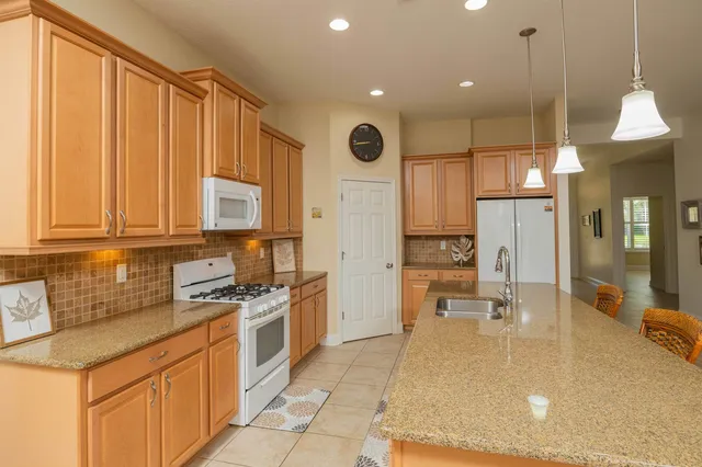 a kitchen with stainless steel appliances granite countertop a stove a sink and a refrigerator