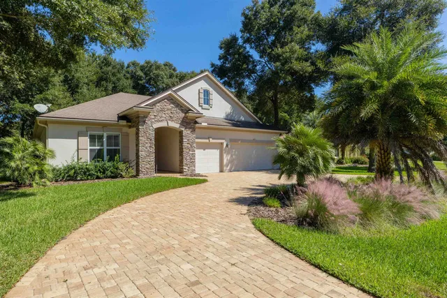 a front view of a house with a garden and plants