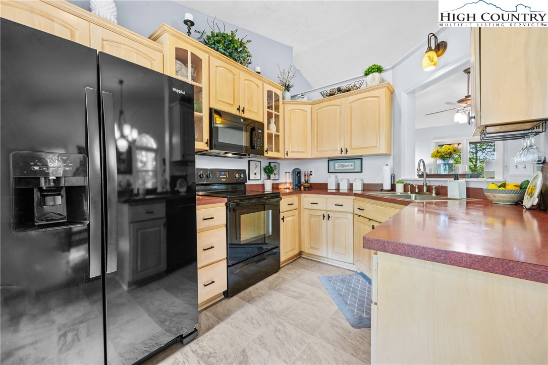 2587 Junaluska Road Boone, NC 28607 - Photo 13 of 47 a kitchen with stainless steel appliances granite countertop a refrigerator a stove and a sink with cabinets