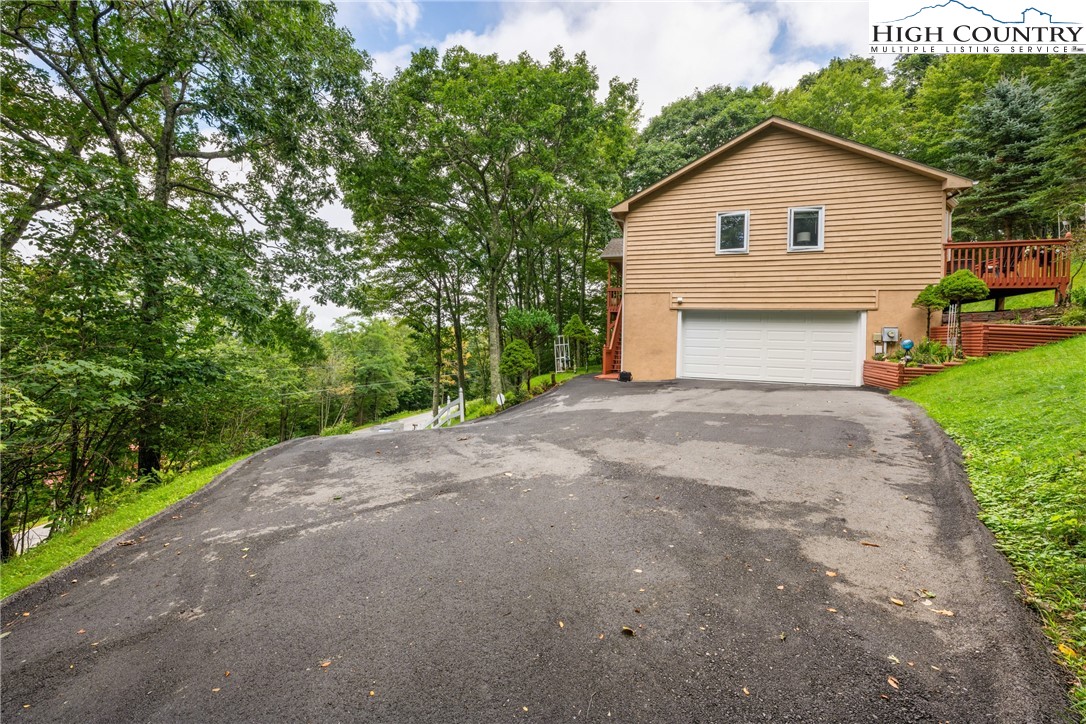 2587 Junaluska Road Boone, NC 28607 - Photo 38 of 47 a view of a house with a yard and garage