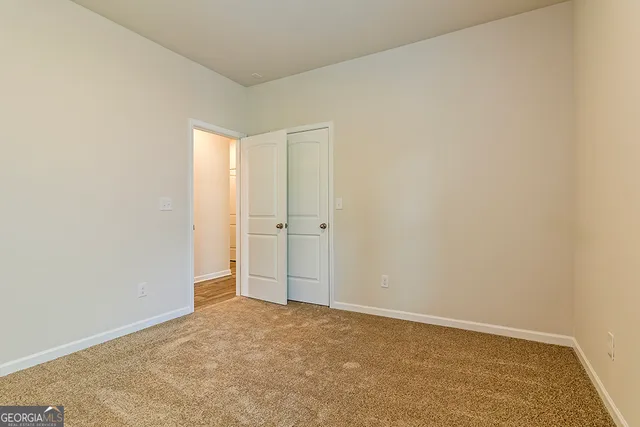 an empty room with ceiling fan and window