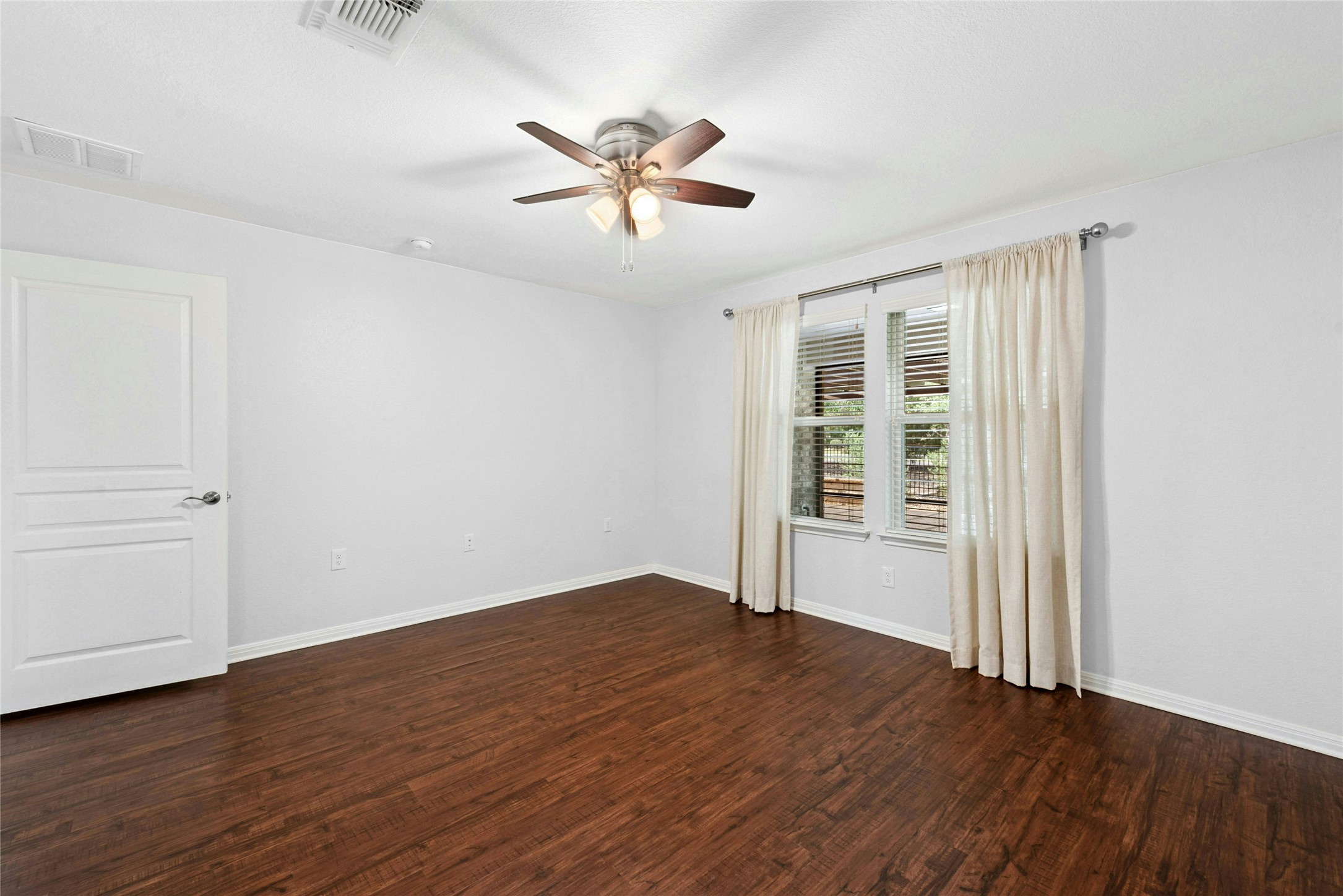 407 Fannin Court Georgetown, TX 78633 - Photo 15 of 40 an empty room with wooden floor fan and windows