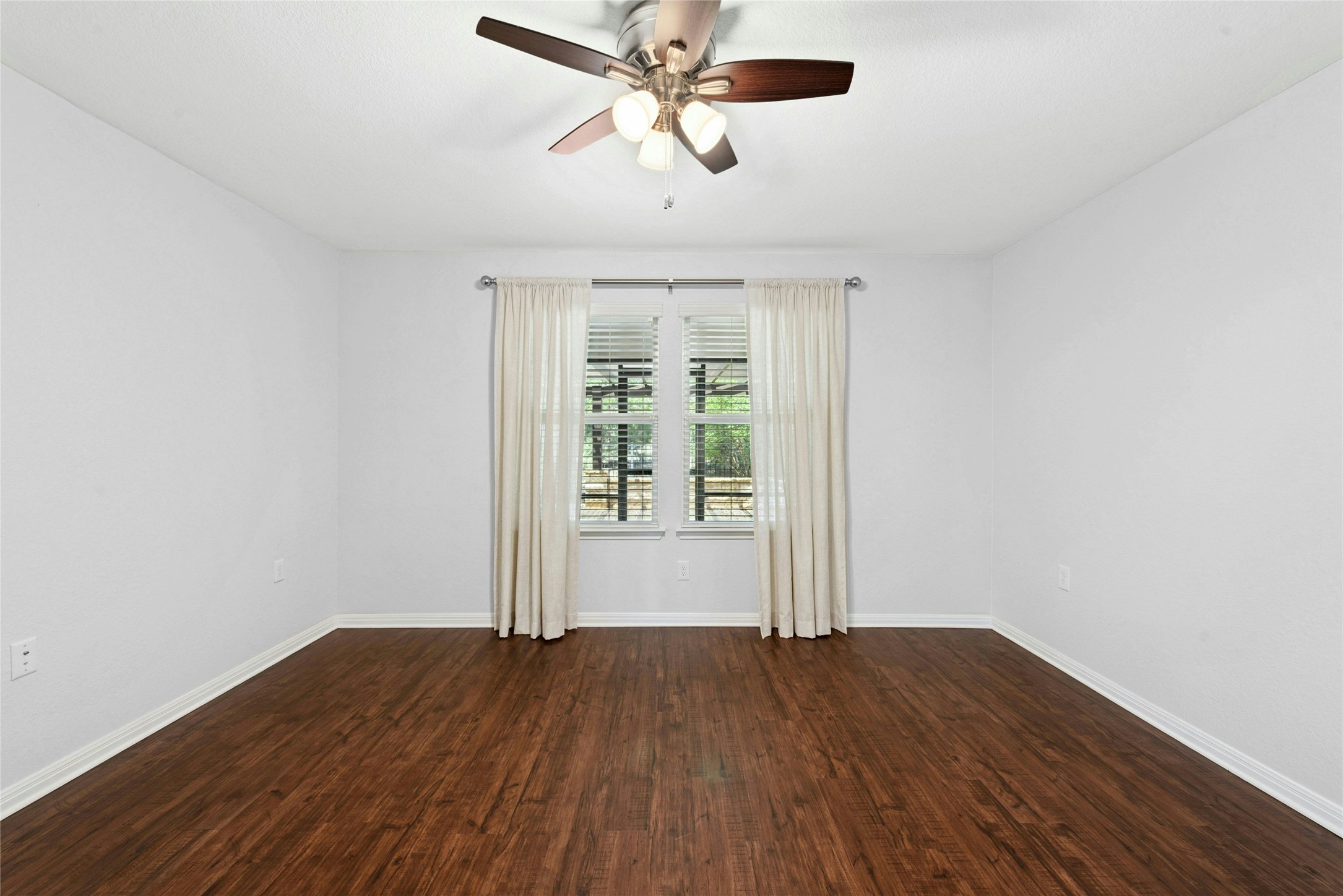 407 Fannin Court Georgetown, TX 78633 - Photo 16 of 40 an empty room with wooden floor chandelier fan and windows
