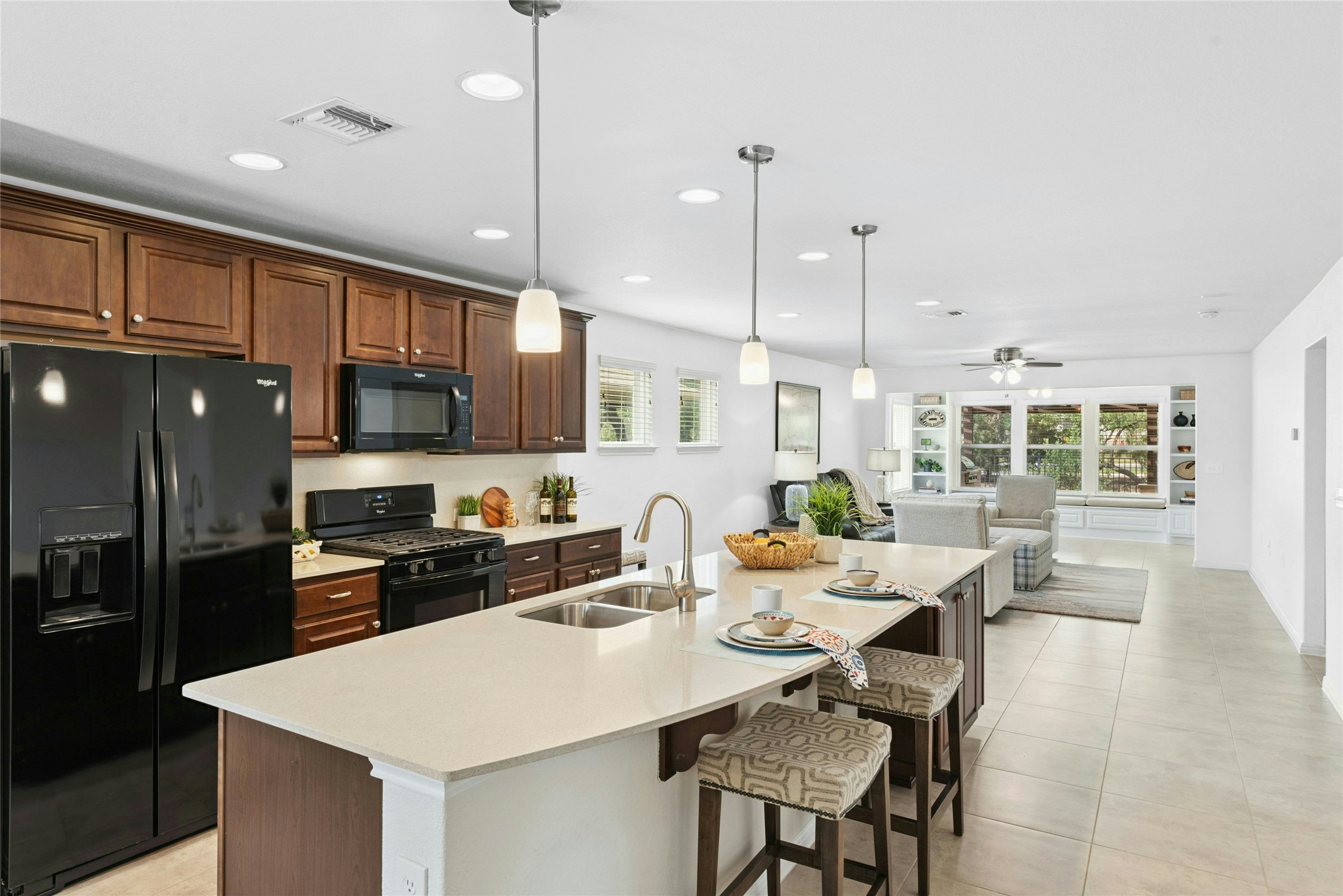 407 Fannin Court Georgetown, TX 78633 - Photo 8 of 40 a kitchen with stainless steel appliances kitchen island granite countertop a stove a sink a refrigerator a dining table and chairs with wooden floor