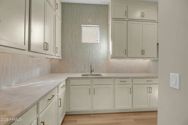 a kitchen with stainless steel appliances granite countertop a sink a stove a refrigerator and white cabinets with wooden floor