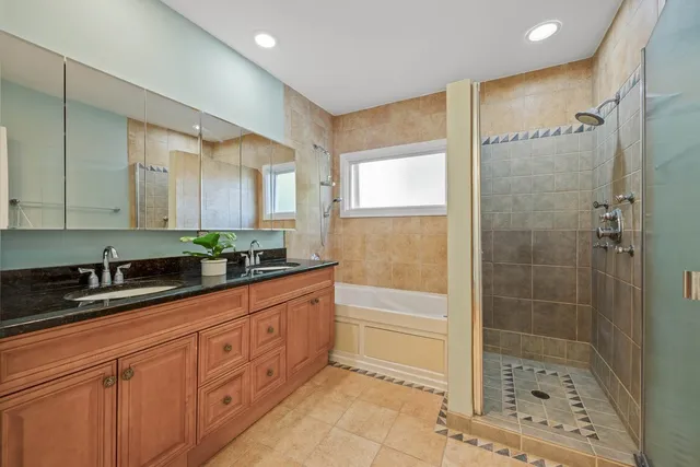 a bathroom with a bathtub shower sink and mirror