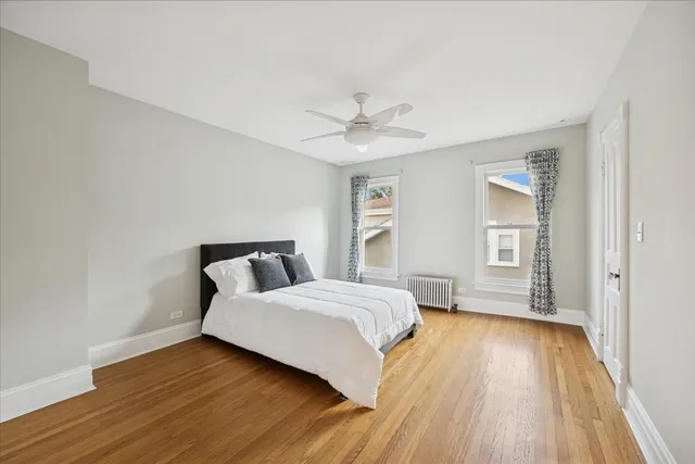 a bedroom with a bed and a ceiling fan