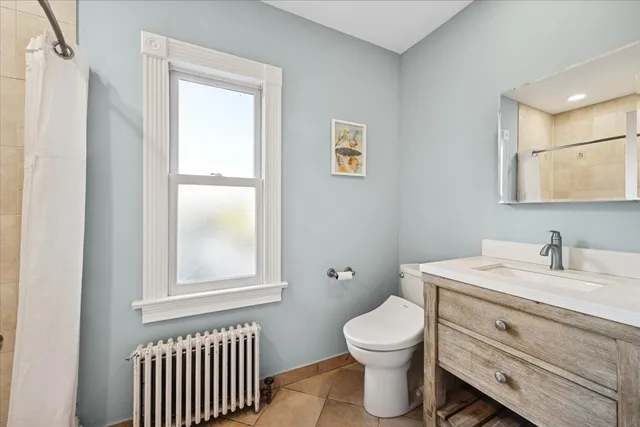a bathroom with a toilet a sink and a window