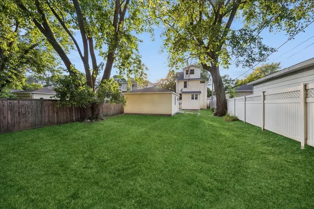 a white house that has tree in front of it
