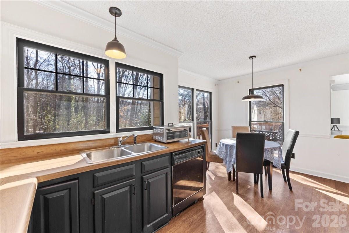 4107 Brownes Ferry Road Charlotte, NC 28269 - Photo 17 of 42 a kitchen with a table chairs and wooden cabinets