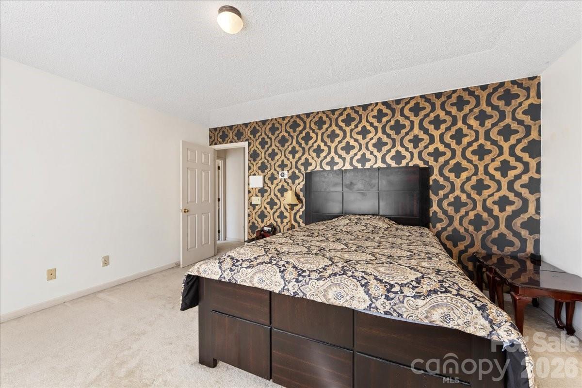 4107 Brownes Ferry Road Charlotte, NC 28269 - Photo 30 of 42 a bedroom with a bed and a wall painting