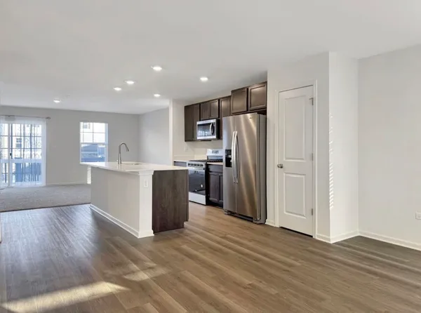 a kitchen with stainless steel appliances a refrigerator and wooden floor