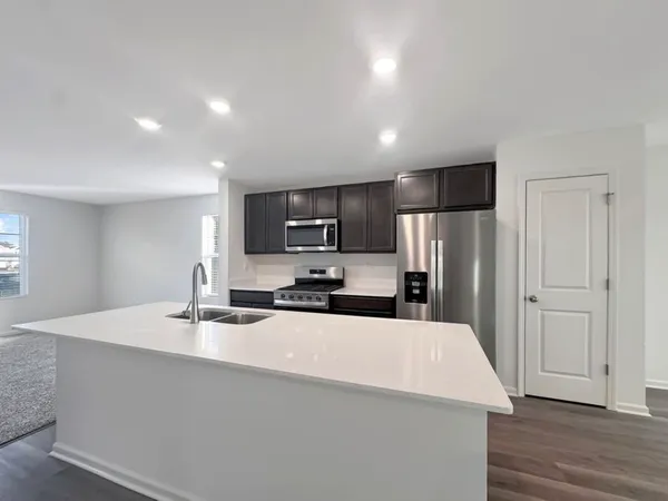 a kitchen with stainless steel appliances a refrigerator sink and microwave