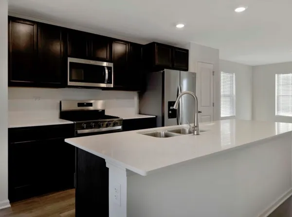 a kitchen with stainless steel appliances a sink a stove a microwave and cabinets