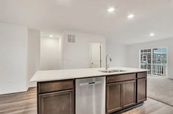 a kitchen with a sink cabinets and wooden floor